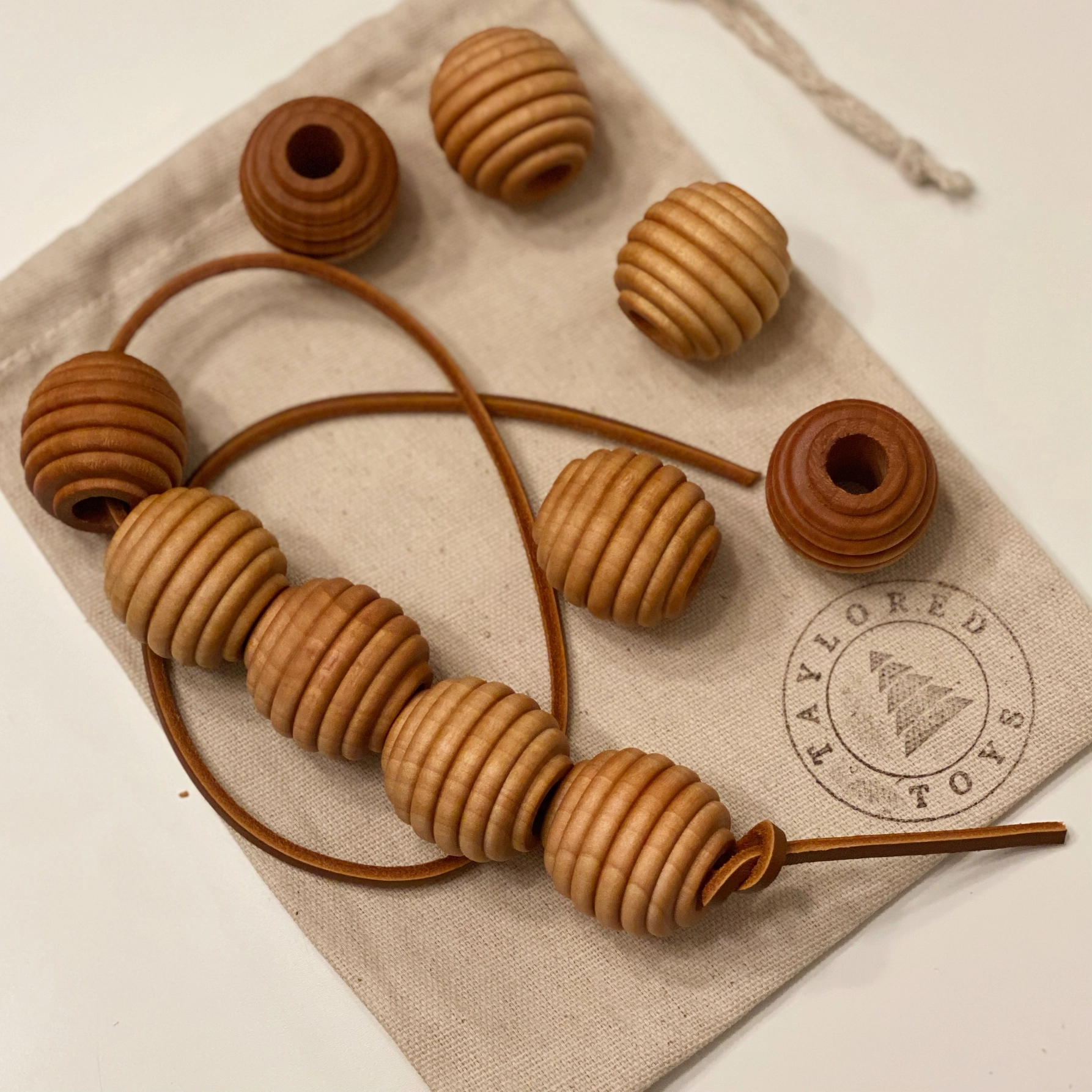 Perline Montessori in legno con cordoncino in pelle Taylored Toys - immagine 3
